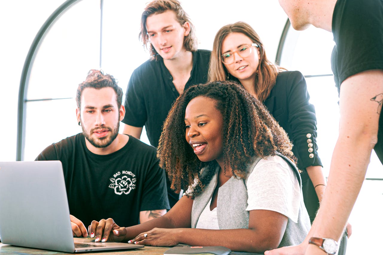 The Art of Drawing Readers In: Your attractive post title goes here A diverse group of young professionals collaborating around a laptop in a modern office setting. Perfect for business or tech concepts.