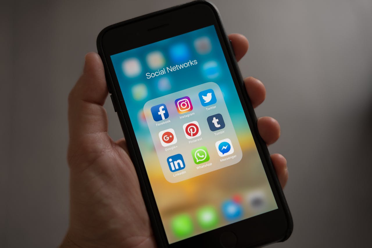 Crafting Captivating Headlines: Your awesome post title goes here A smartphone displaying various social media icons held in a hand, showcasing modern communication apps.